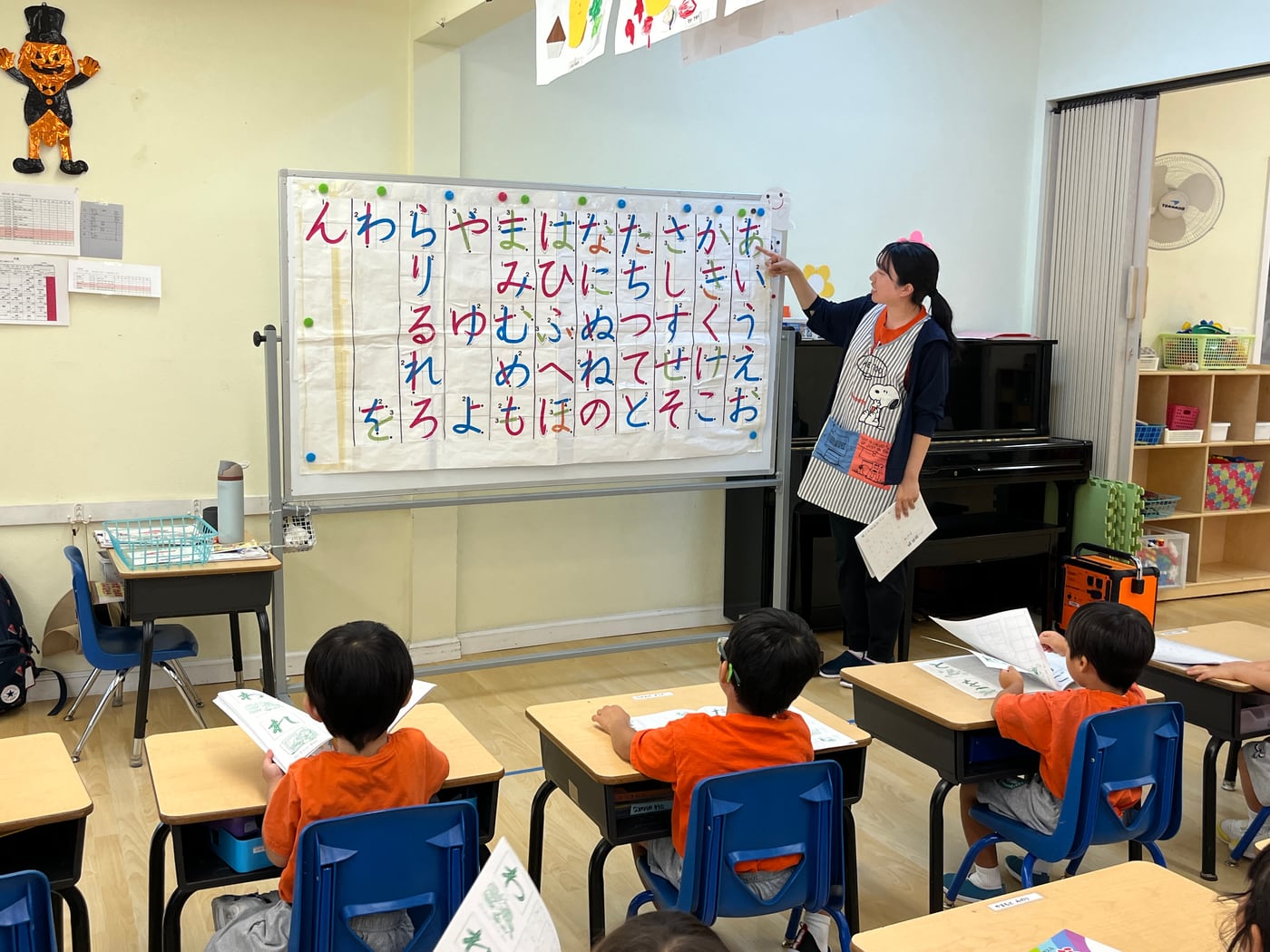 ひらがなの文字表を使い、先生と一緒に学ぶ園児たち