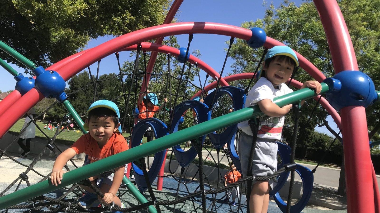 園庭の遊具で体を動かす子どもたち